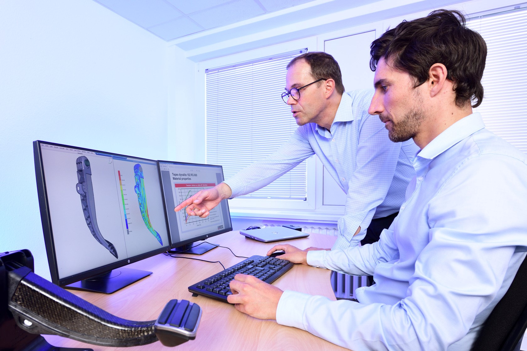 HPM HiAnt通过CAD模拟、全塑料制动踏板、Frank Lutter（伸臂，站立）和Henrik Alpmann（坐在屏幕前）支持部件的开发